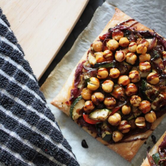 two mediterranean vegetable tarts on a dining table, shot from above