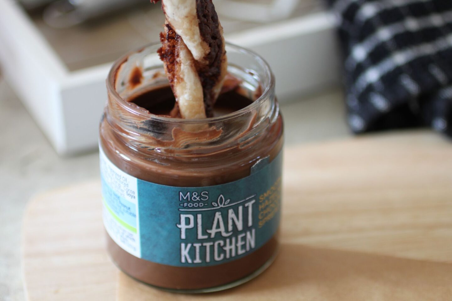 a vegan Nutella pastry twist getting dipped into a jar of vegan nutella