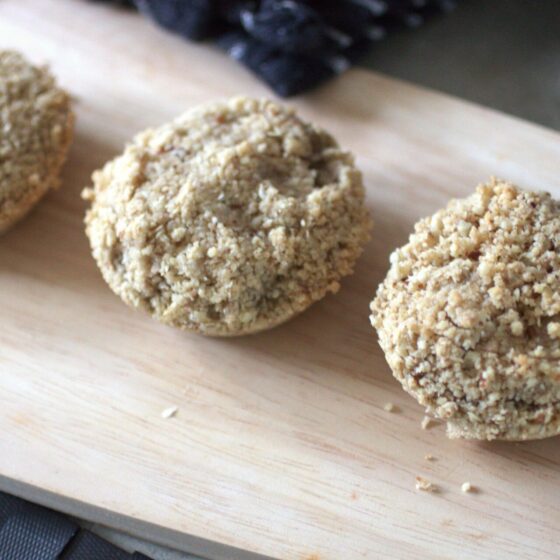 a wooden tray with three rhubarb crumble cookies placed on it