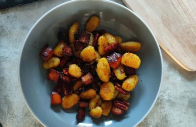 a grey pasta bowl filled with roasted squash gnocchi