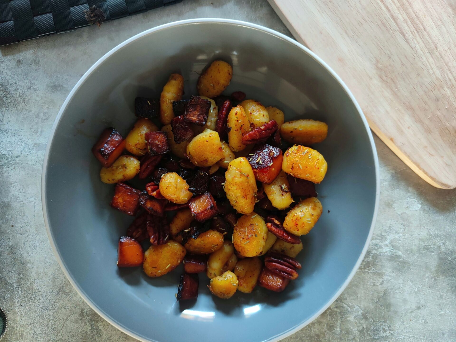 a grey pasta bowl filled with roasted squash gnocchi