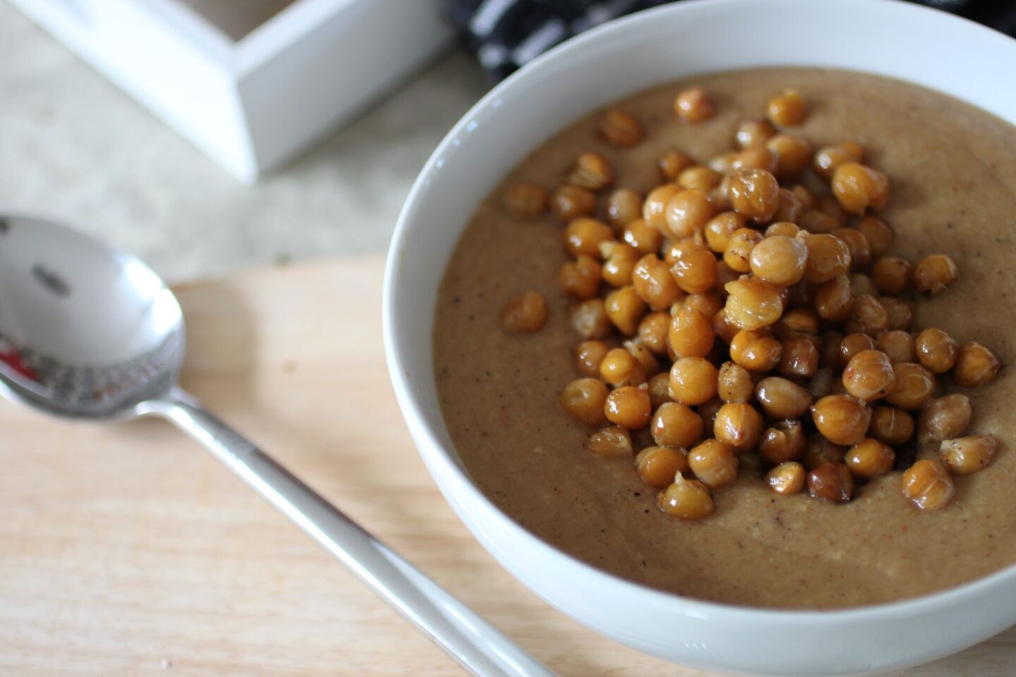 a bowl of spiced cauliflower soup showing the chickpeas on the top, like a crouton