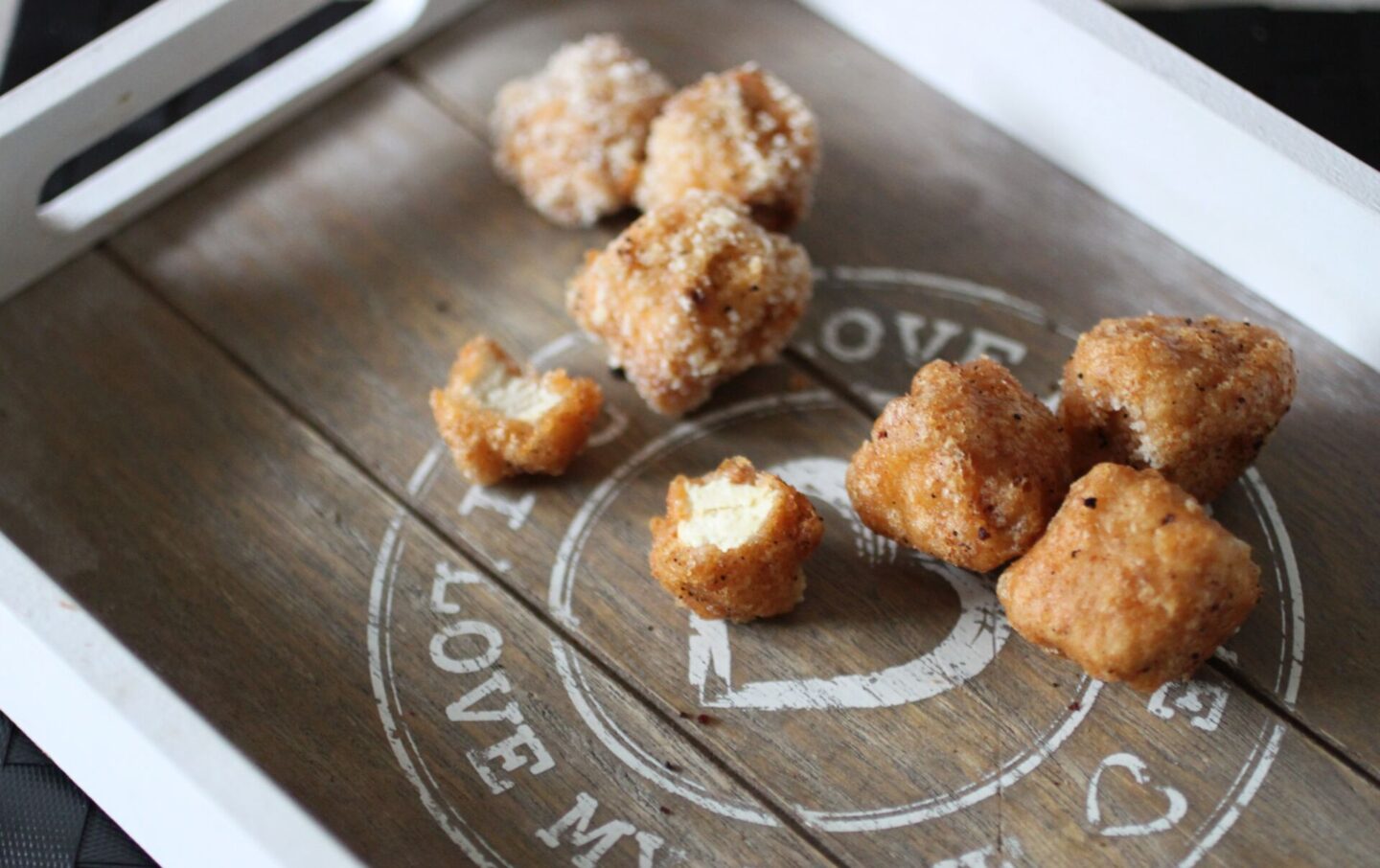 some tofu bites on a tray, one cut open to show the insides