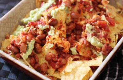 a dish of vegan nachos showing all of the layers