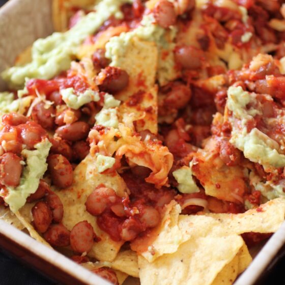 a dish of vegan nachos showing all of the layers