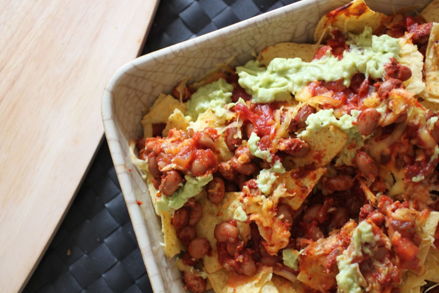 a dish of vegan nachos showing the layers