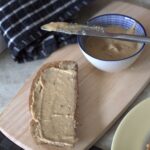 pot of vegan white chocolate hazelnut spread and a slice of toast topped with it
