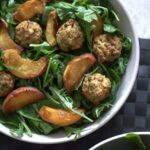 a bowl of balsamic baked peach salad on a place mat