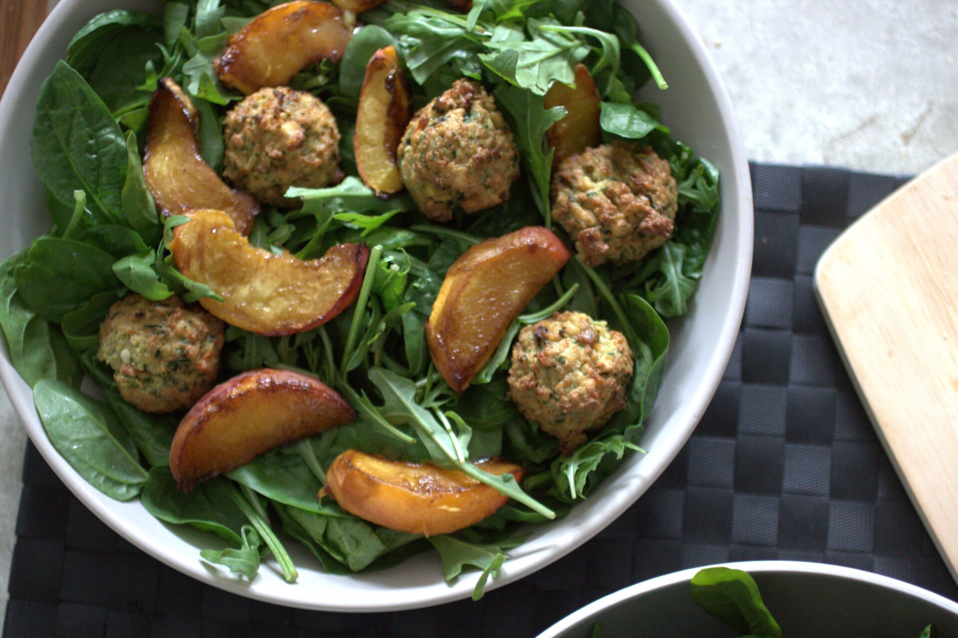 a bowl of balsamic baked peach salad on a place mat