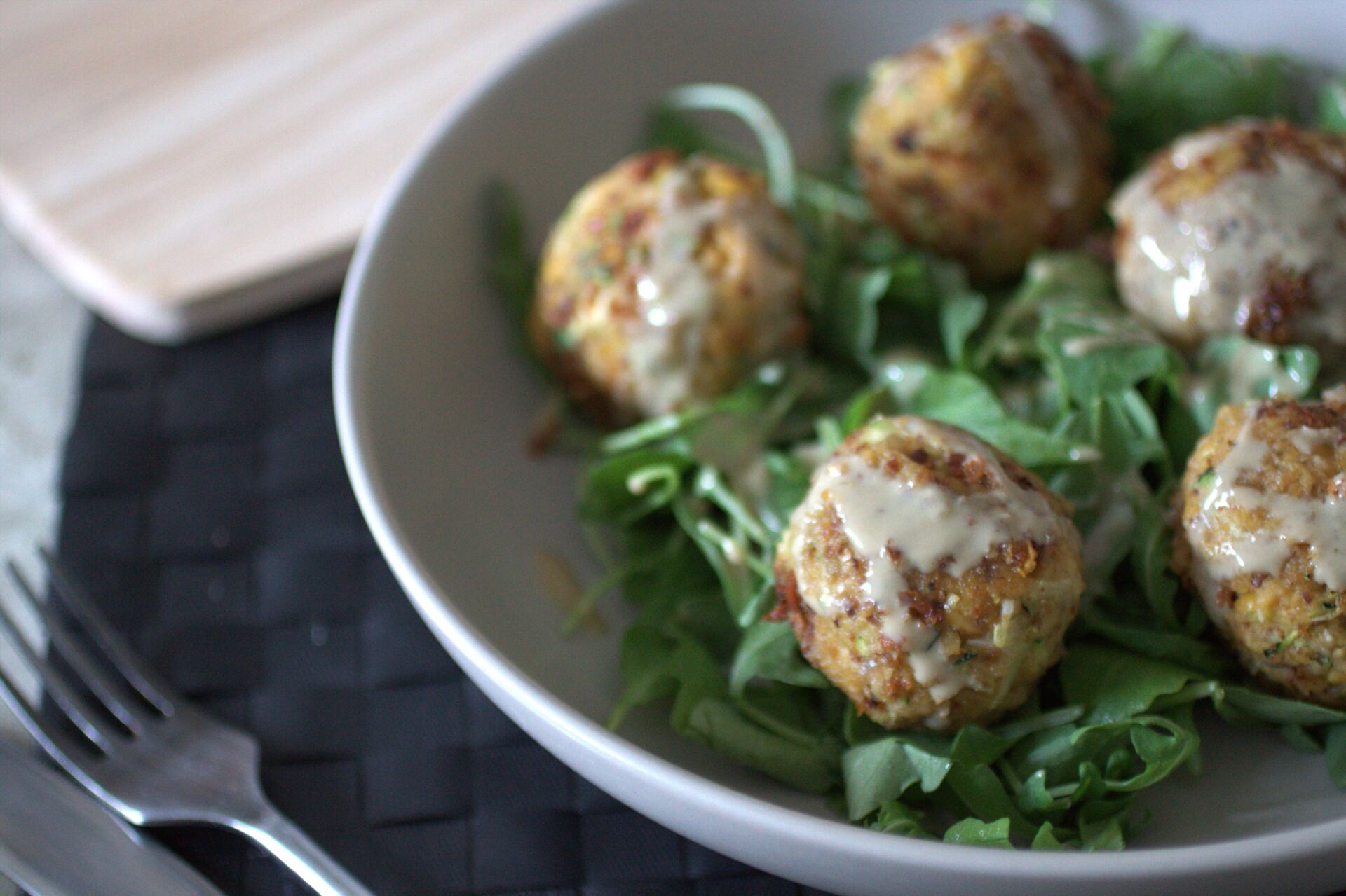 bowl of courgette falafel drizzled with tahini