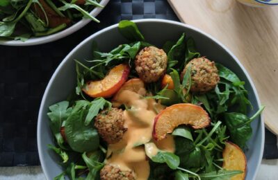 large bowl filled with balsamic baked peach salad and peach salad dressing