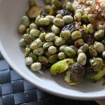 crispy roasted broad beans in a bowl with some roasted sprouts