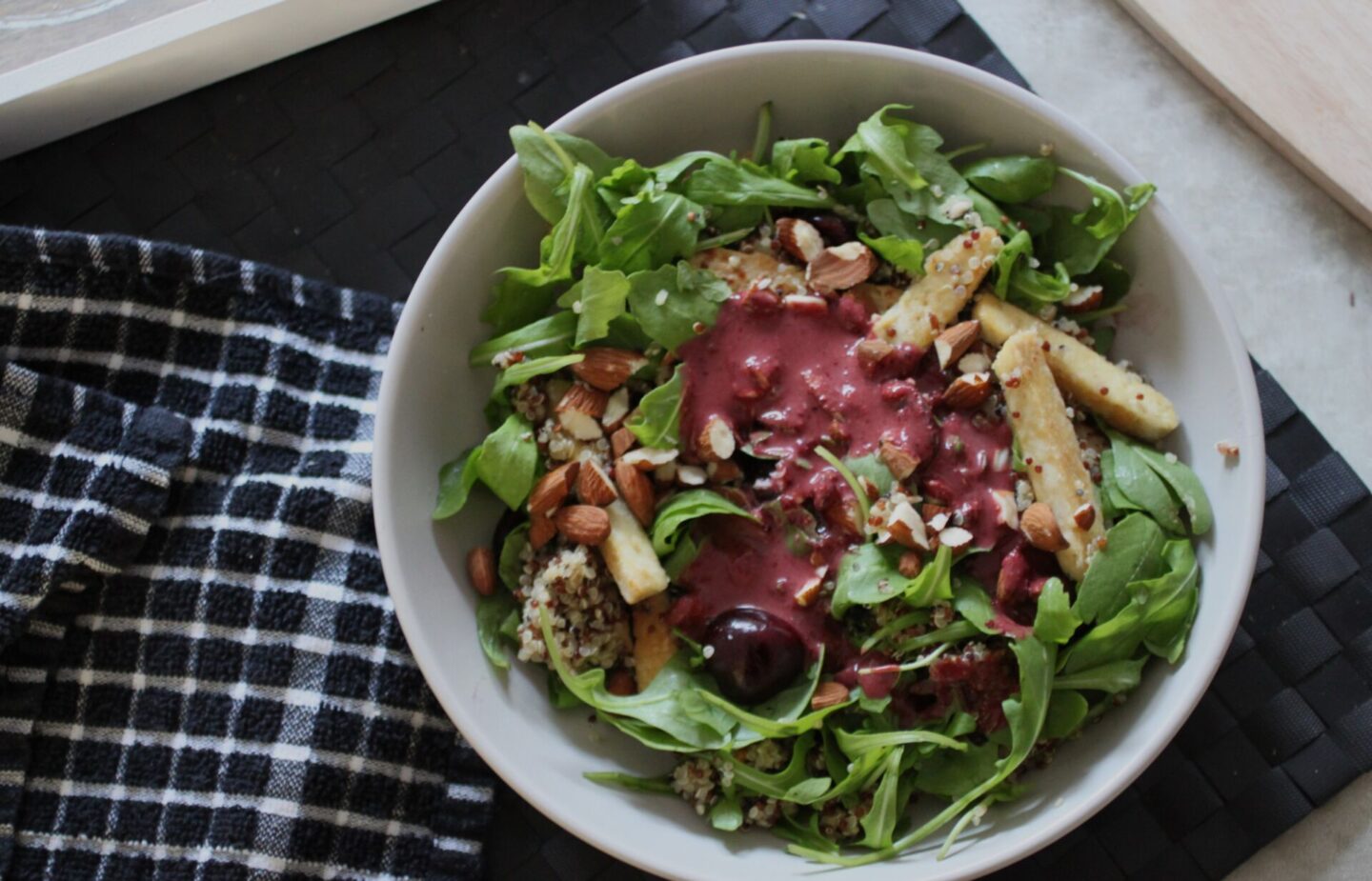 bowl of cherry quinoa salad with cherry balsamic pored over it, before it has been combined
