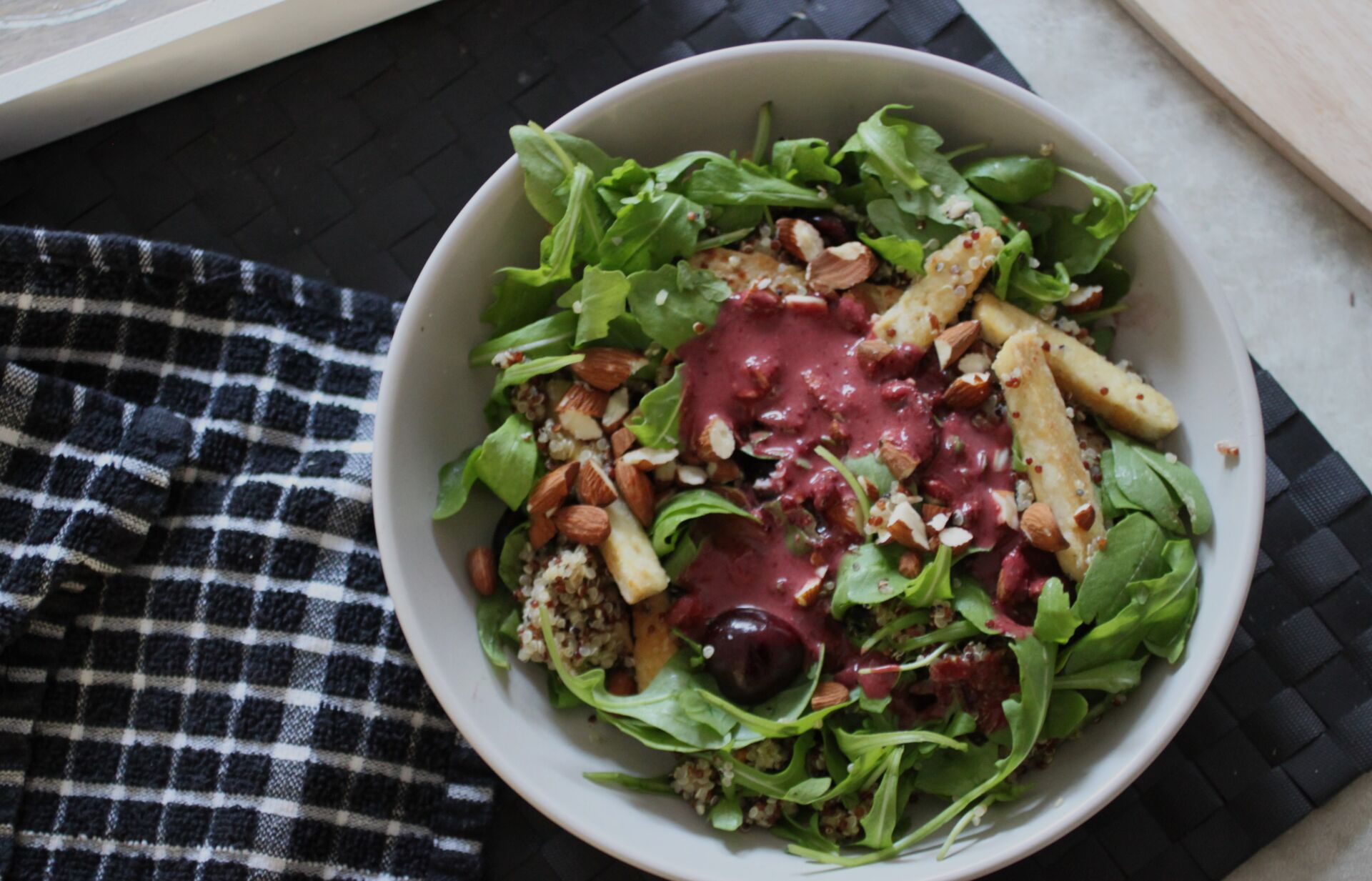 bowl of cherry quinoa salad with cherry balsamic pored over it, before it has been combined