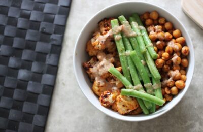Roasted harissa cauliflower bowl drizzled with dressing