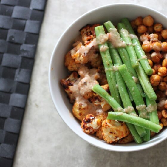 Roasted harissa cauliflower bowl drizzled with dressing