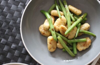 a bowl of gluten free vegan gnocchi with green beans