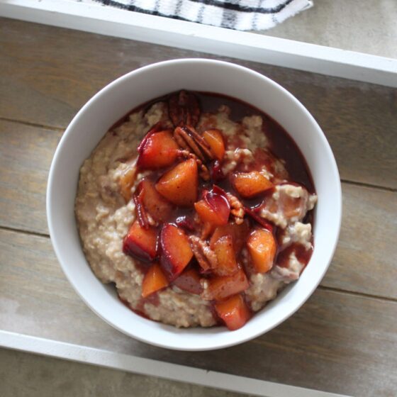 bowl of spiced plum oats on a wooden board, shot from above