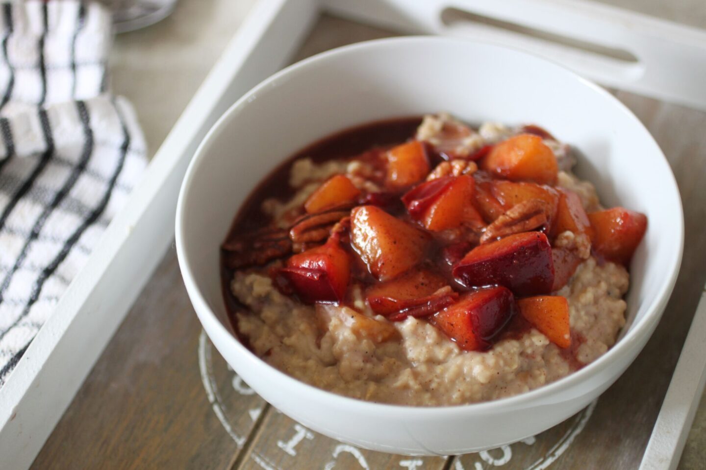 bowl of spiced plum oats on a wooden board