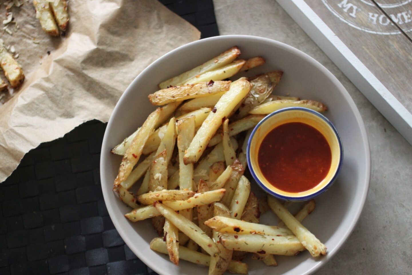 bowl of vegan parm fries with chilli sauce