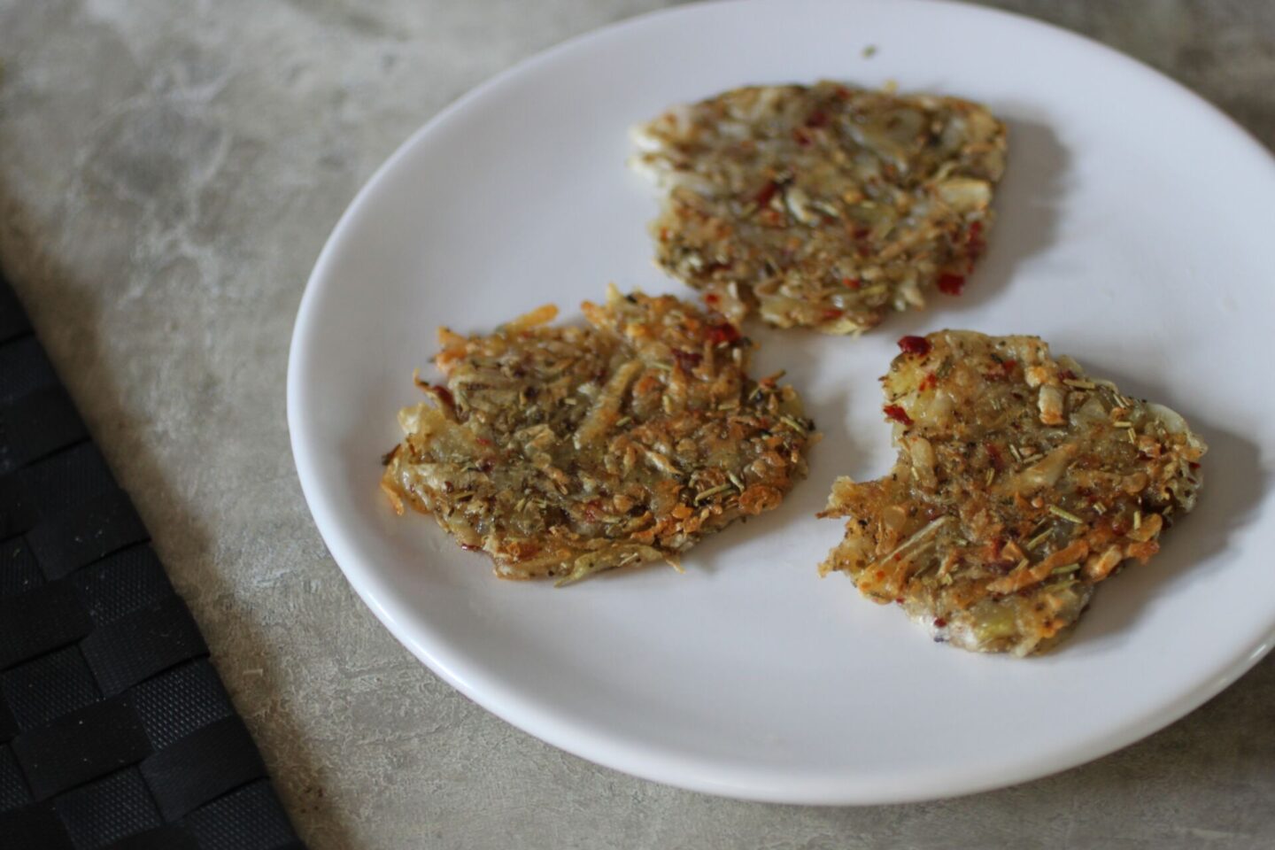 three celeriac hash, fried, on a white plate