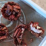 chocolate orange quinoa nests on a wooden tray, one sliced open to show the layers/ texture
