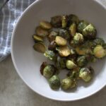 bowl of maple roasted sprouts placed on a table, shot from above