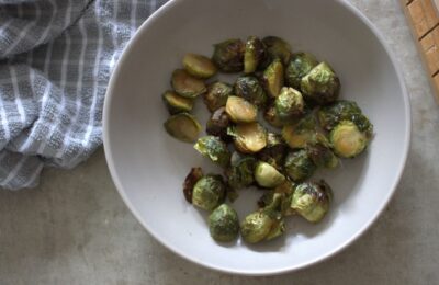 bowl of maple roasted sprouts placed on a table, shot from above