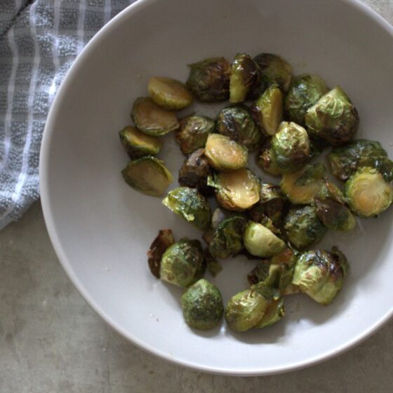 bowl of maple roasted sprouts placed on a table, shot from above
