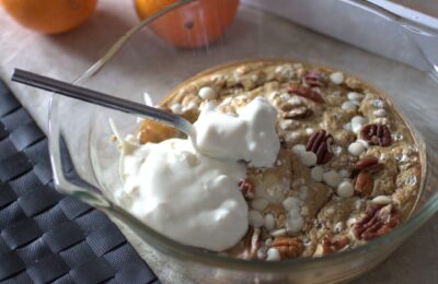 orange baked oats topped with vegan yoghurt in a dish fresh from the oven