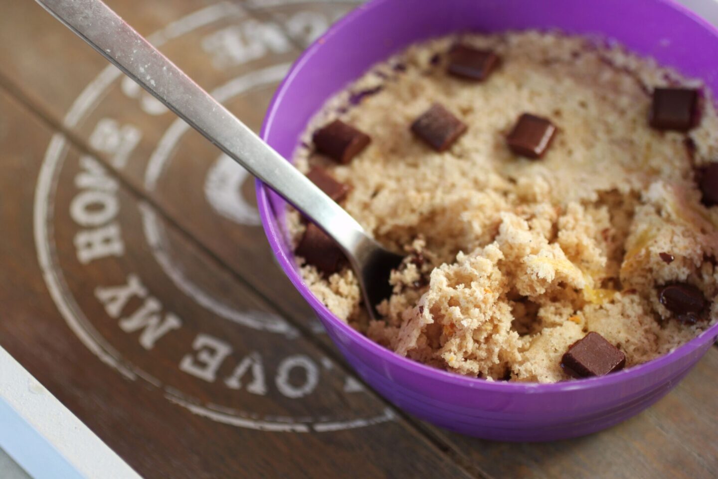 a bowl of orange mug cake with a spoon in it