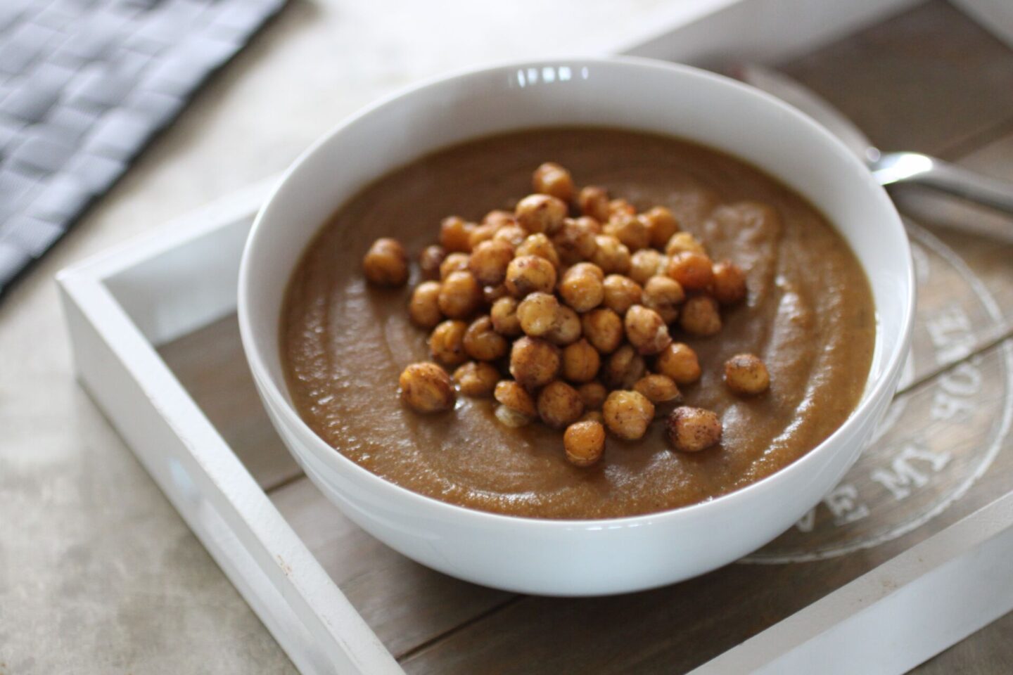 white bowl filled with sweet carrot and lentil soup, topped with roasted chickpeas