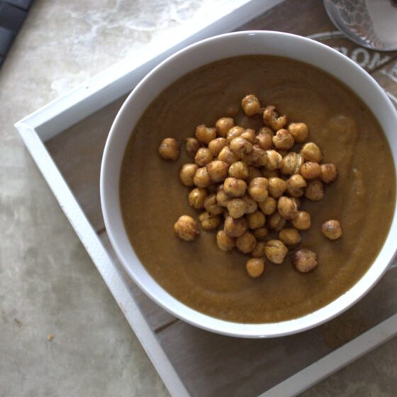 sweet carrot and lentil soup recipe in a white bowl, topped with roasted chickpeas, shot from above