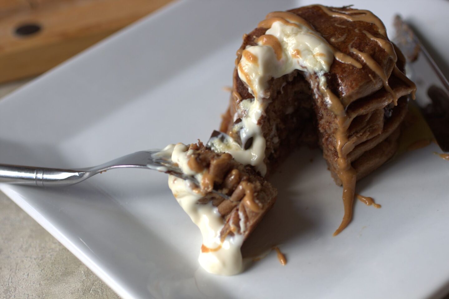 peanut butter protein pancakes with a wedge cut out 