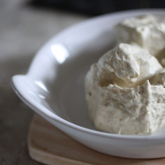 close up shot of a scoop of pineapple protein ice cream in a white dish