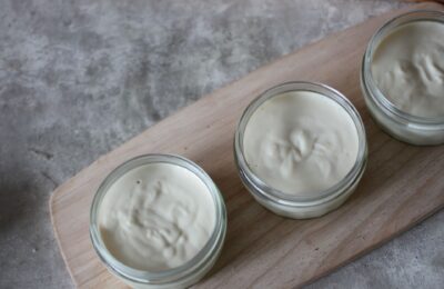 a tray of three lemon mousse pots, shot from above