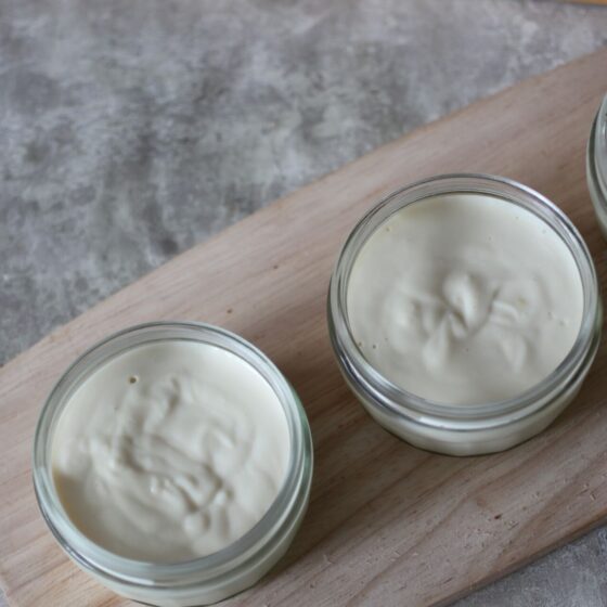 a tray of three lemon mousse pots, shot from above