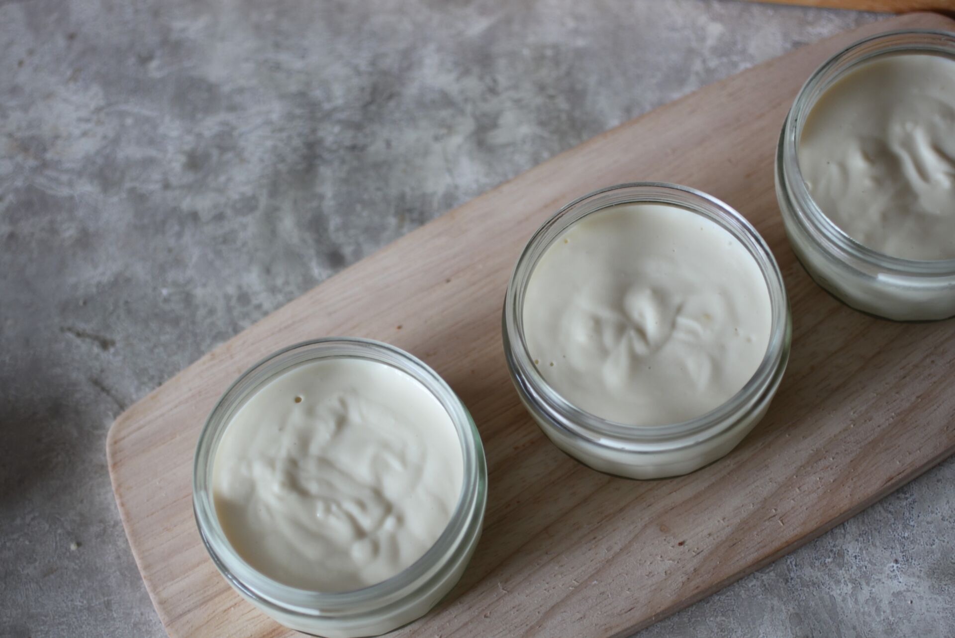 a tray of three lemon mousse pots, shot from above
