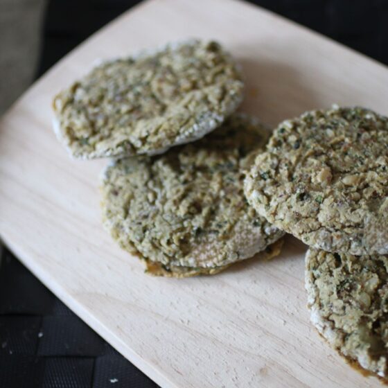 several white bean basil fritters on a wooden board