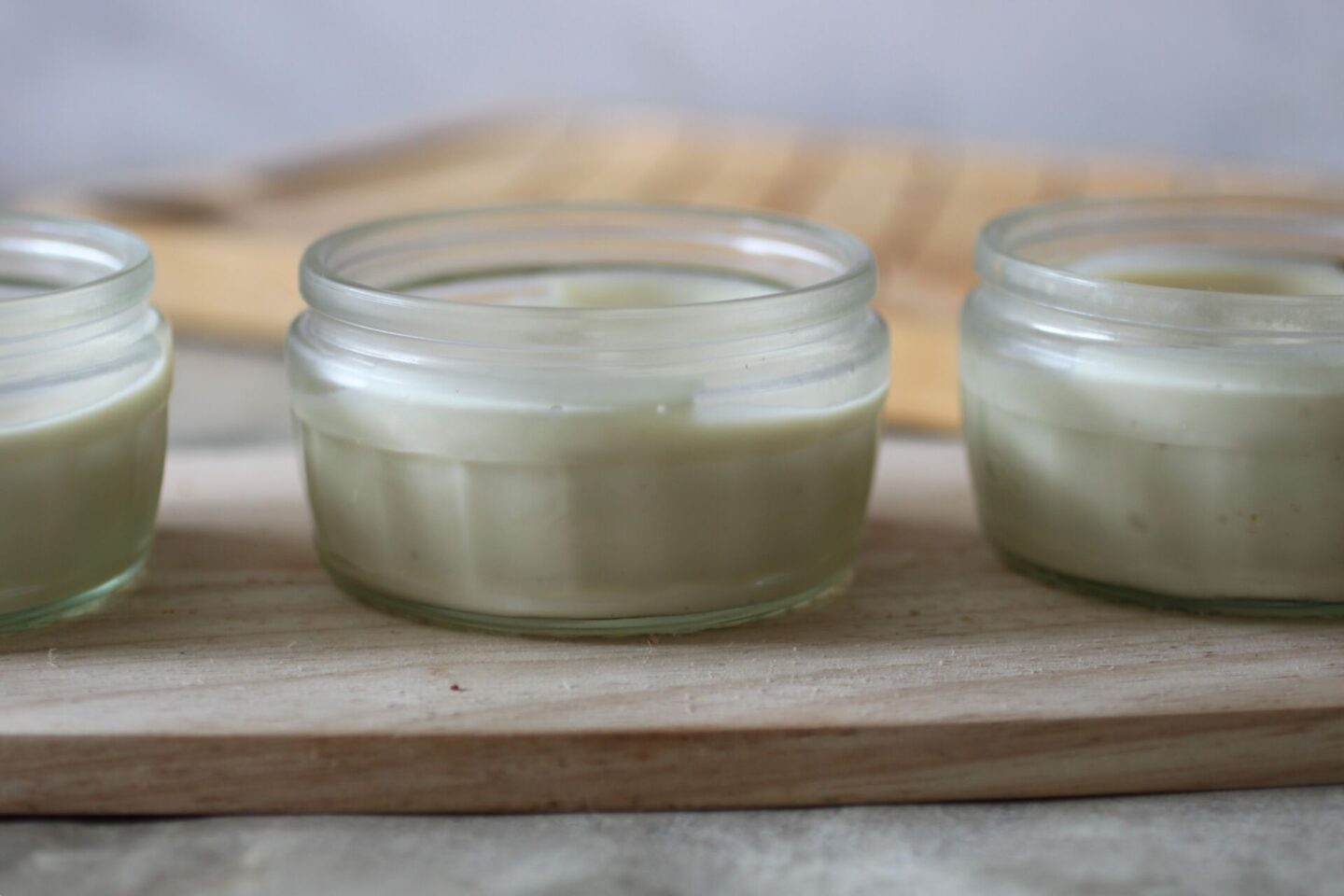 vegan lemon mousse recipe - a tray of mousse pots lined up and shot from the side. 
