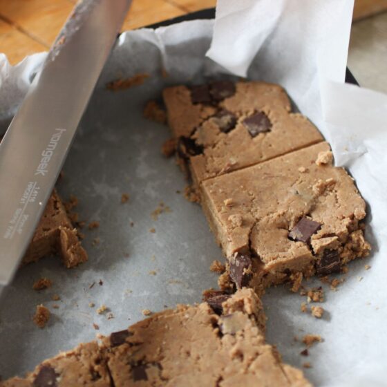 some sliced cookie dough protein bars on a sheet of greaseproof paper