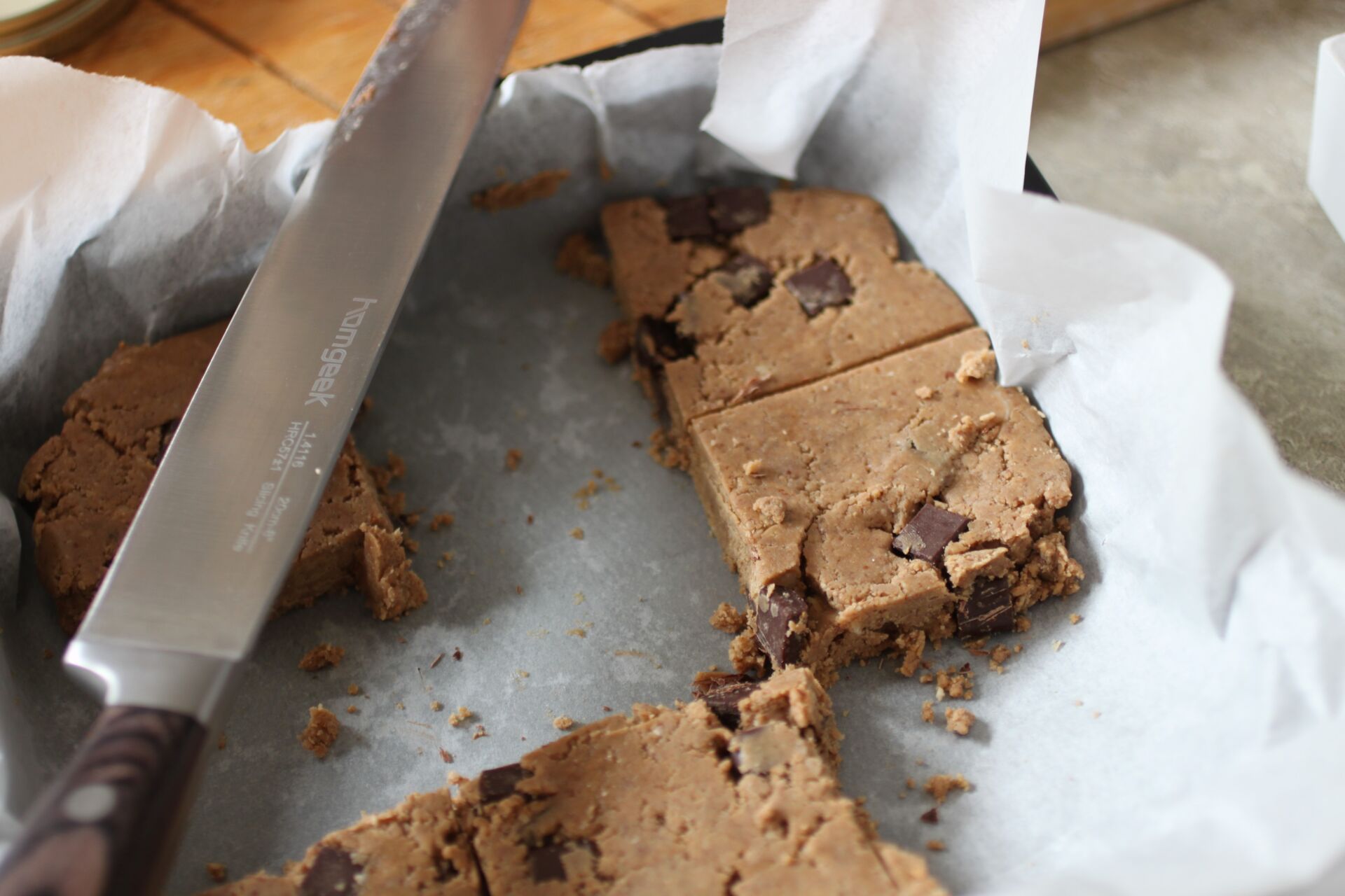 some sliced cookie dough protein bars on a sheet of greaseproof paper