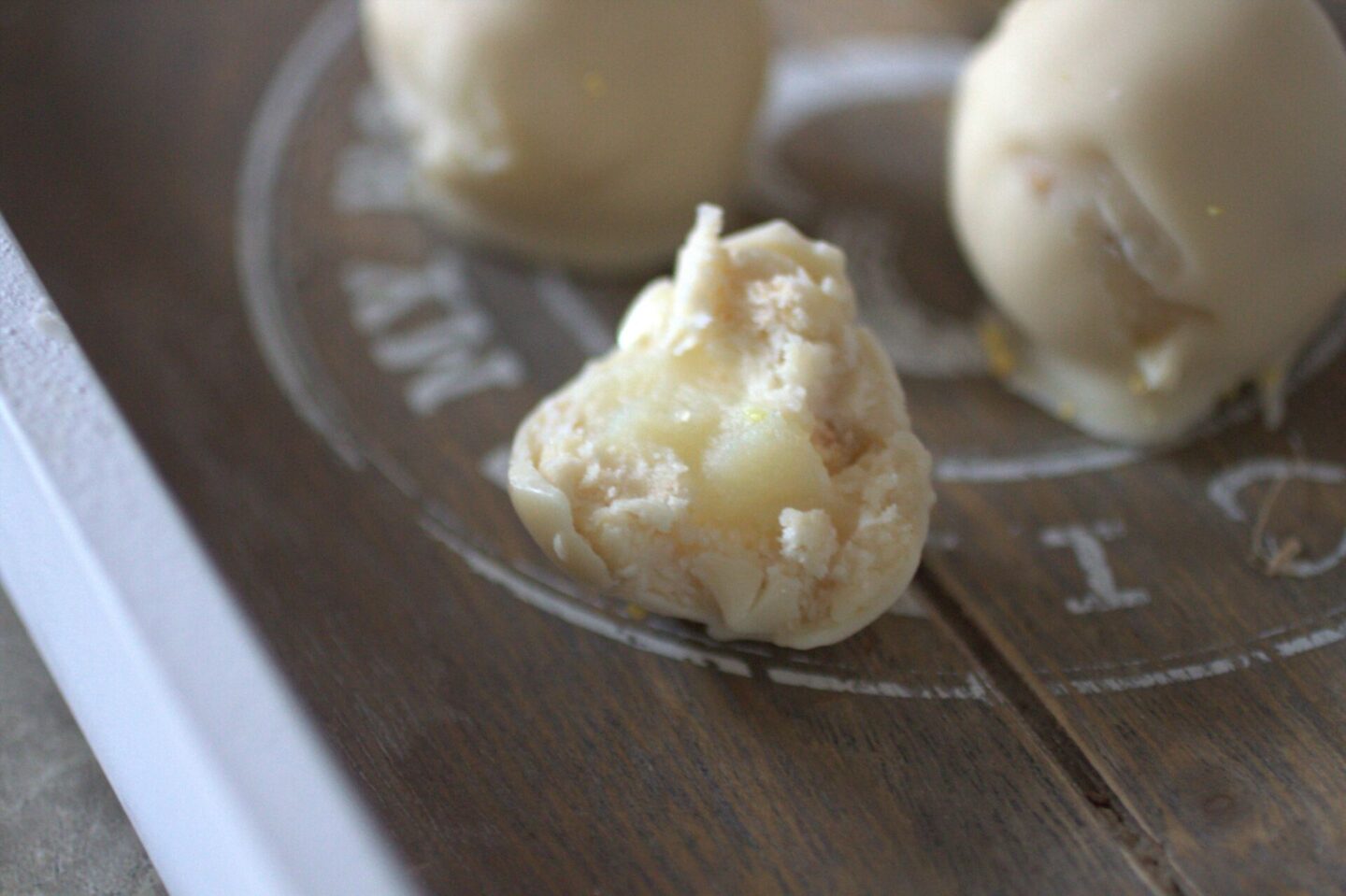 vegan lemon curd running out of the middle of a vegan lemon cheesecake ball