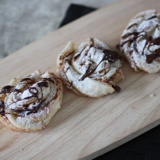 small wooden board with several peanut butter chocolate twists on it