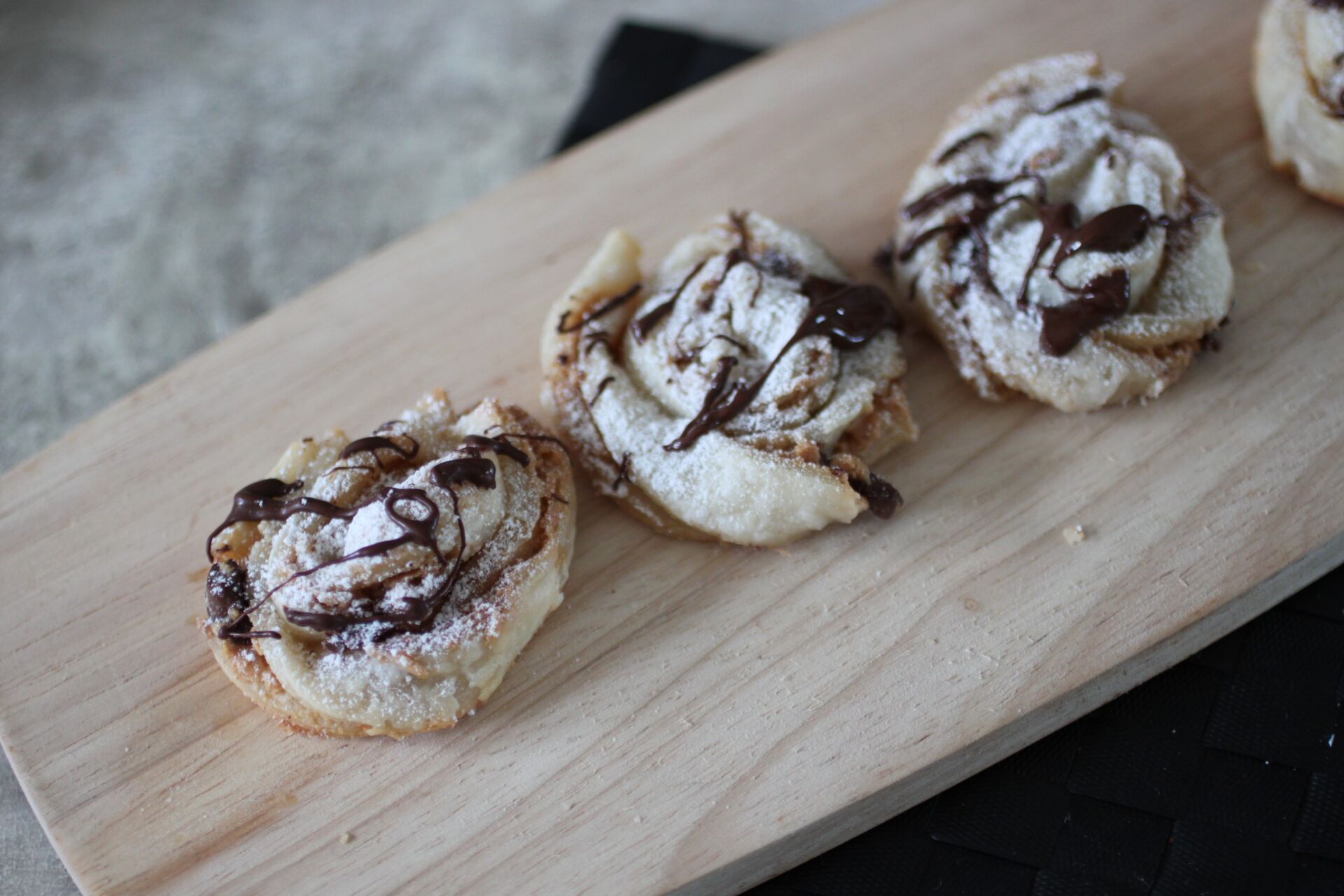 small wooden board with several peanut butter chocolate twists on it