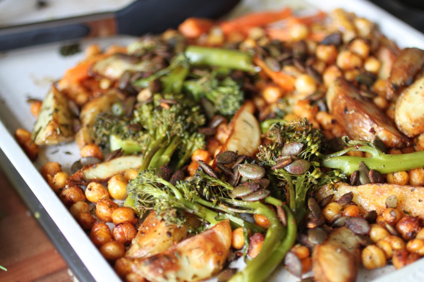 tray of vegetables and chickpeas on a baking tray ready to be added to the bowls