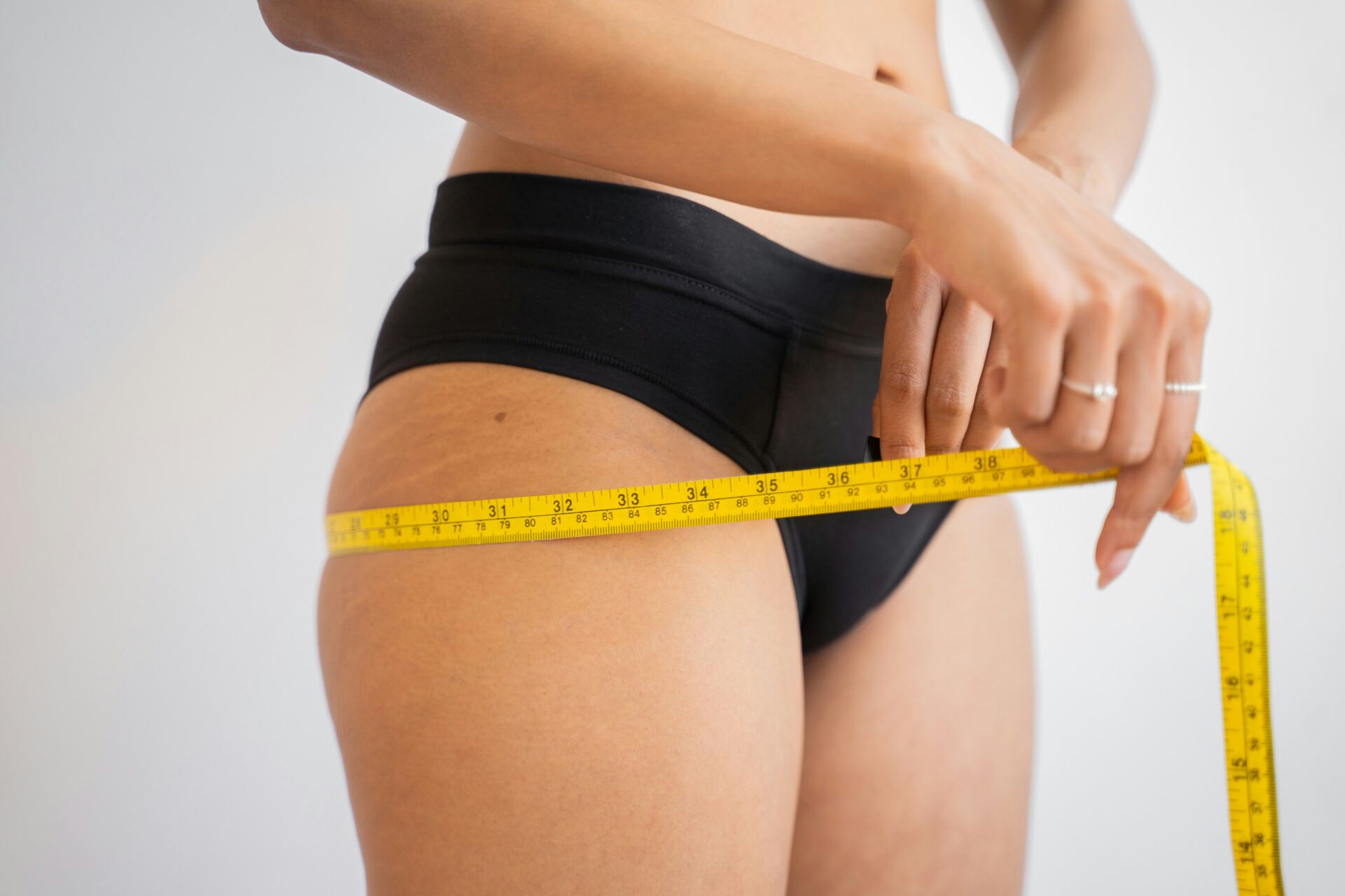 woman with measuring tape around her hips