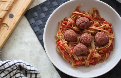bowl of beetroot meatballs with pea pasta