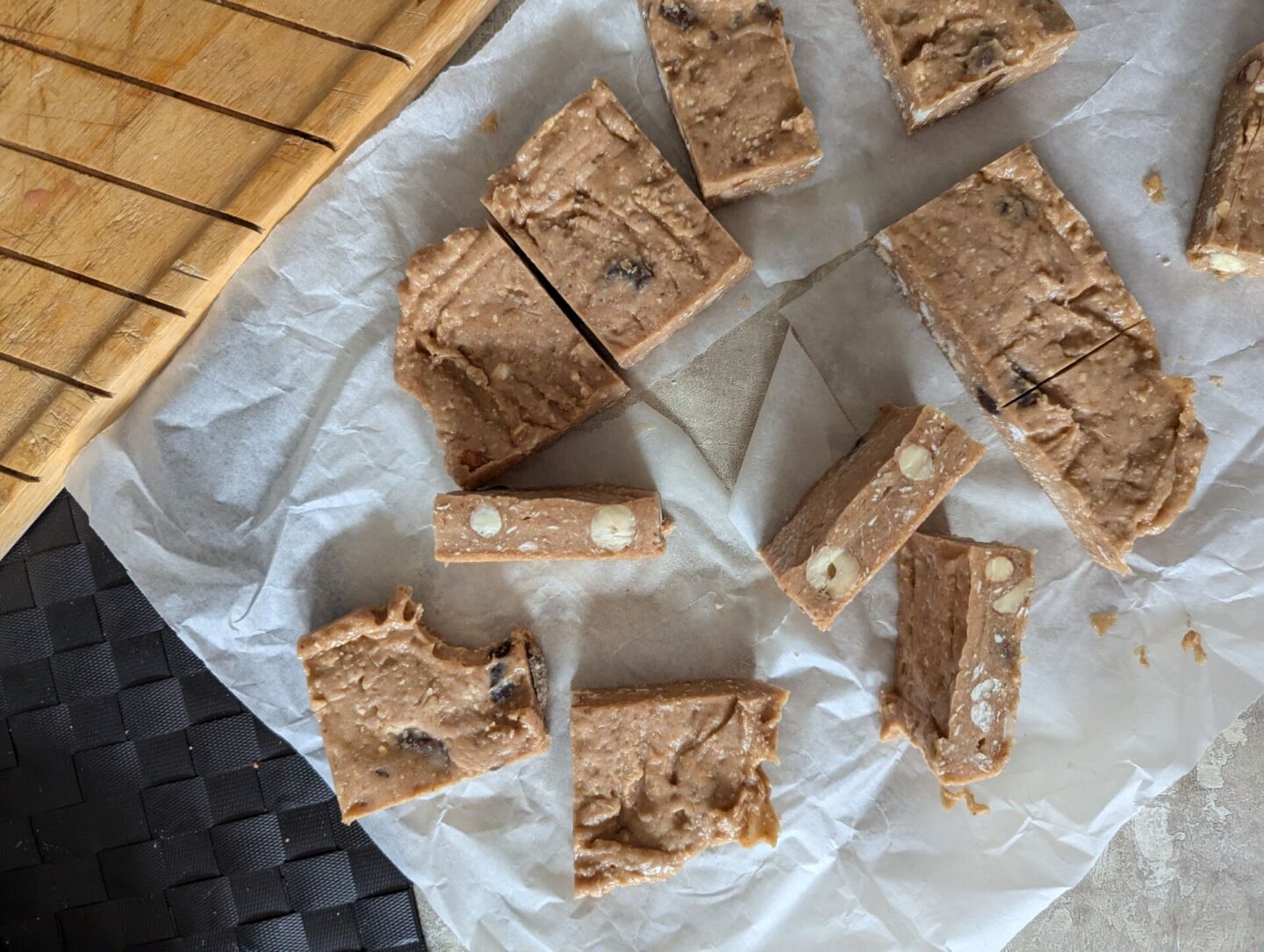 sheet of sliced strawberry white chocolate cookie dough bars on greaseproof paper, shot from above