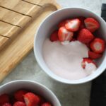 two bowls of chopped strawberries with strawberry cream